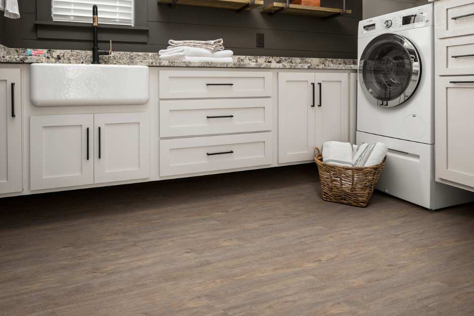 wood look luxury vinyl in laundry room with farmhouse sink